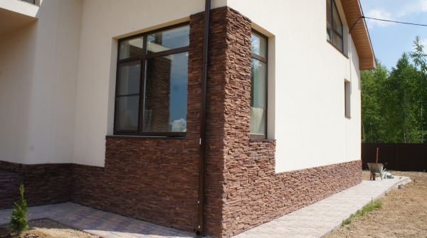 Угол фасада дома оформлен декоративным искусственным камнем